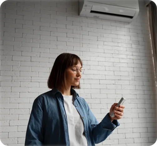 Woman in denim jacket using smartphone against white brick wall