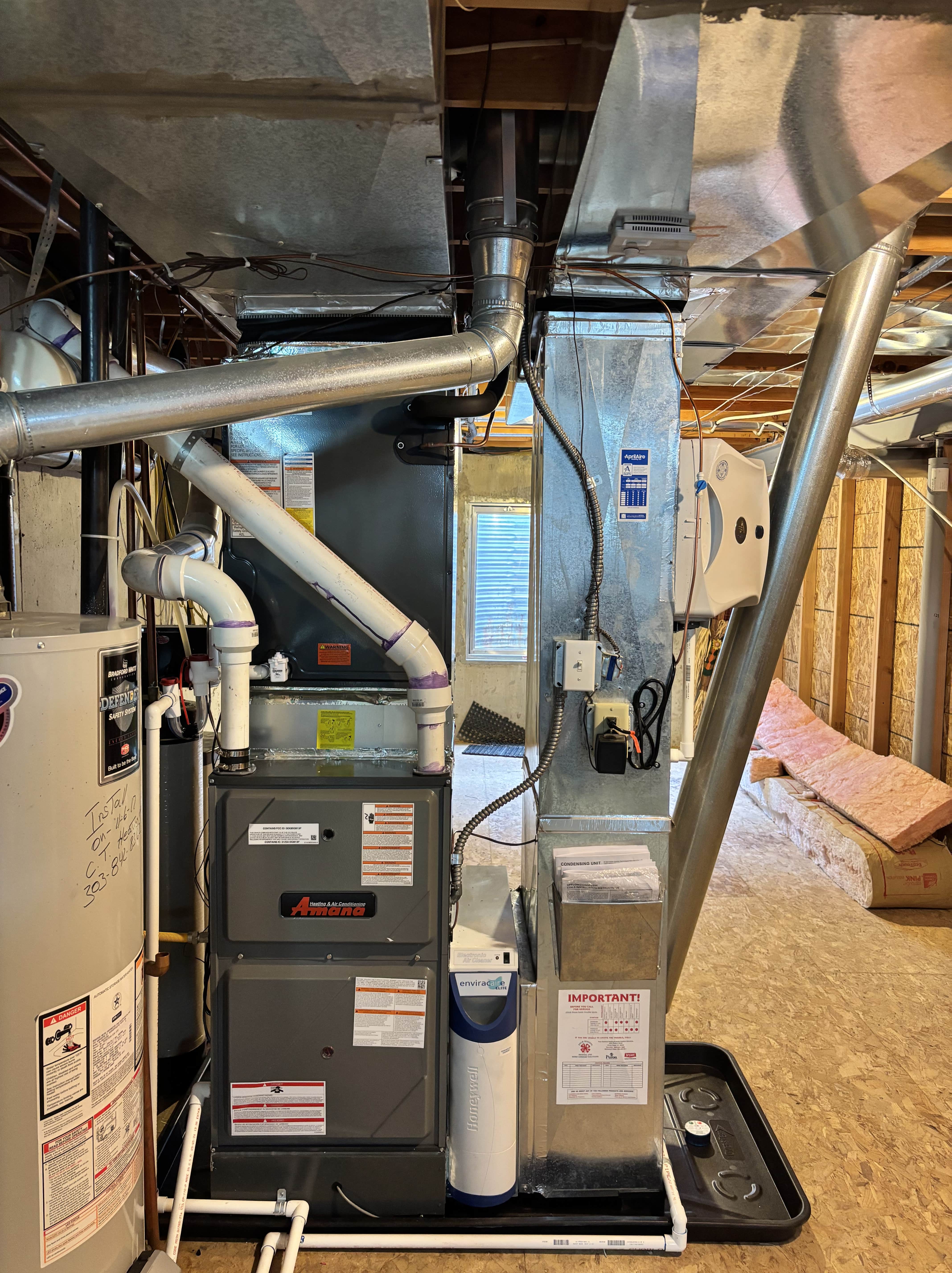 Amana furnace and water heater in basement with metal ductwork