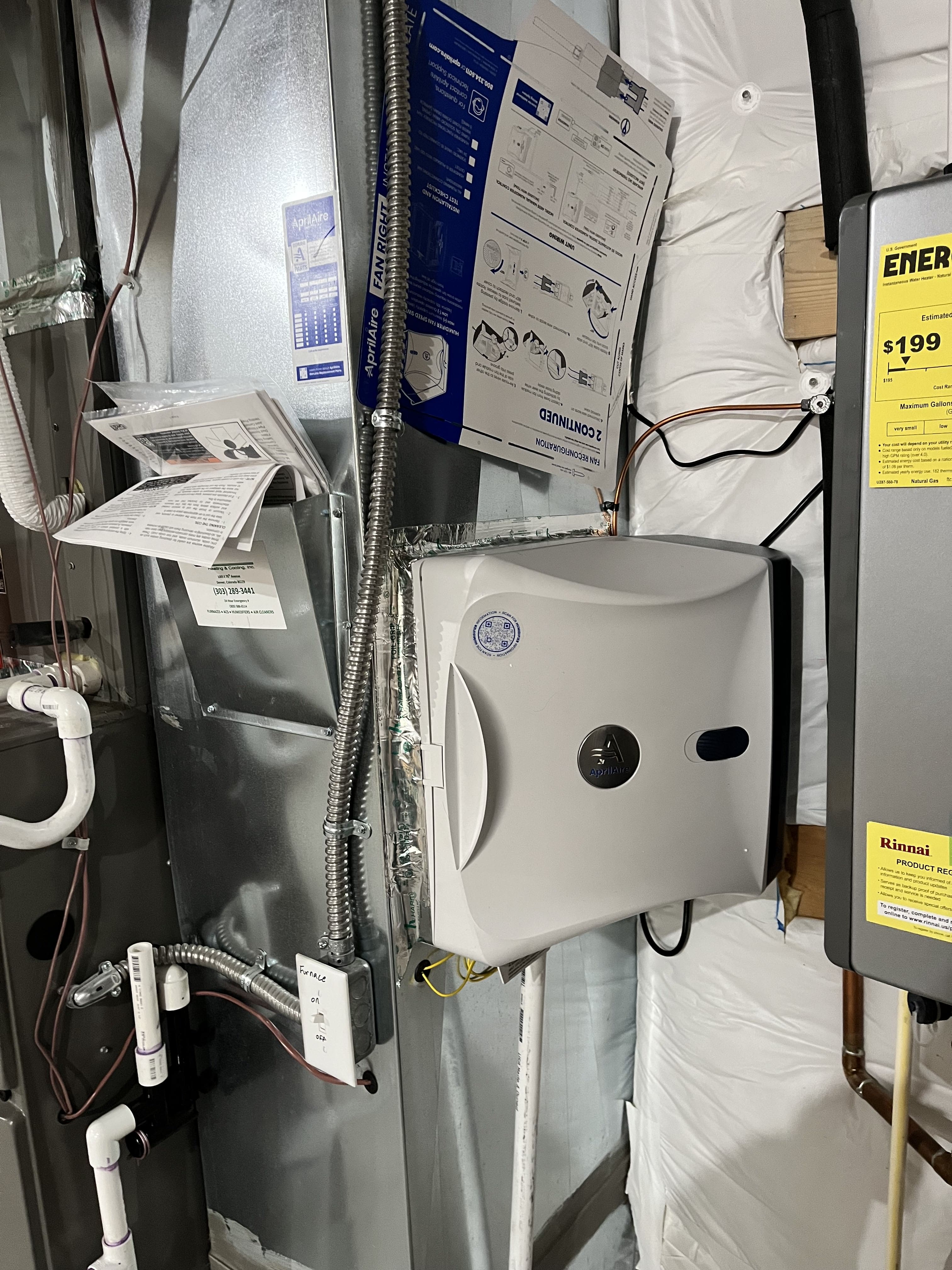 Utility closet with water heater, electrical panels, and installation instructions