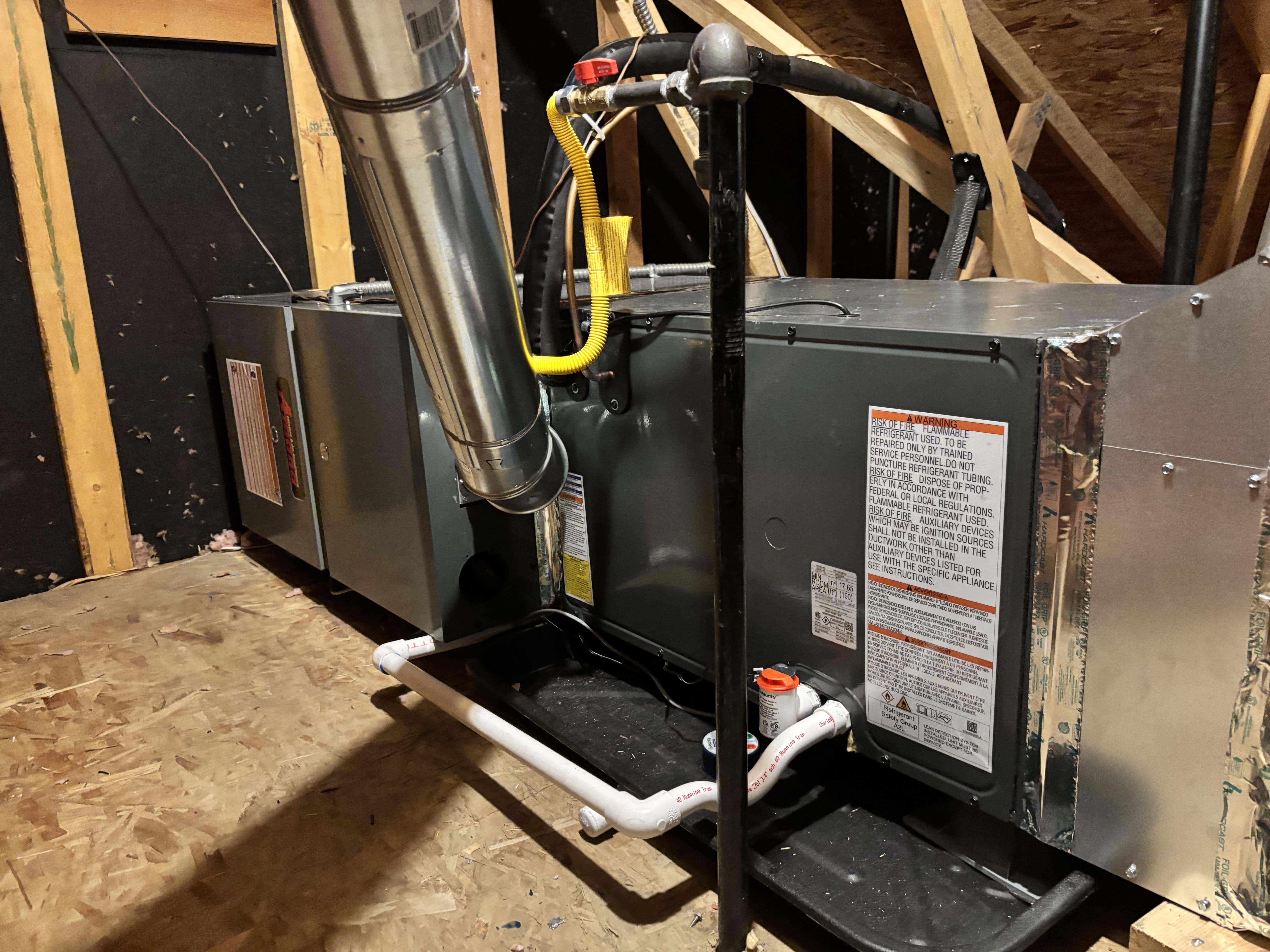 Home HVAC system installed in attic with metal ductwork and pipes