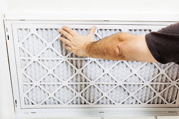 Hand changing dirty air filter in HVAC system or home ventilation