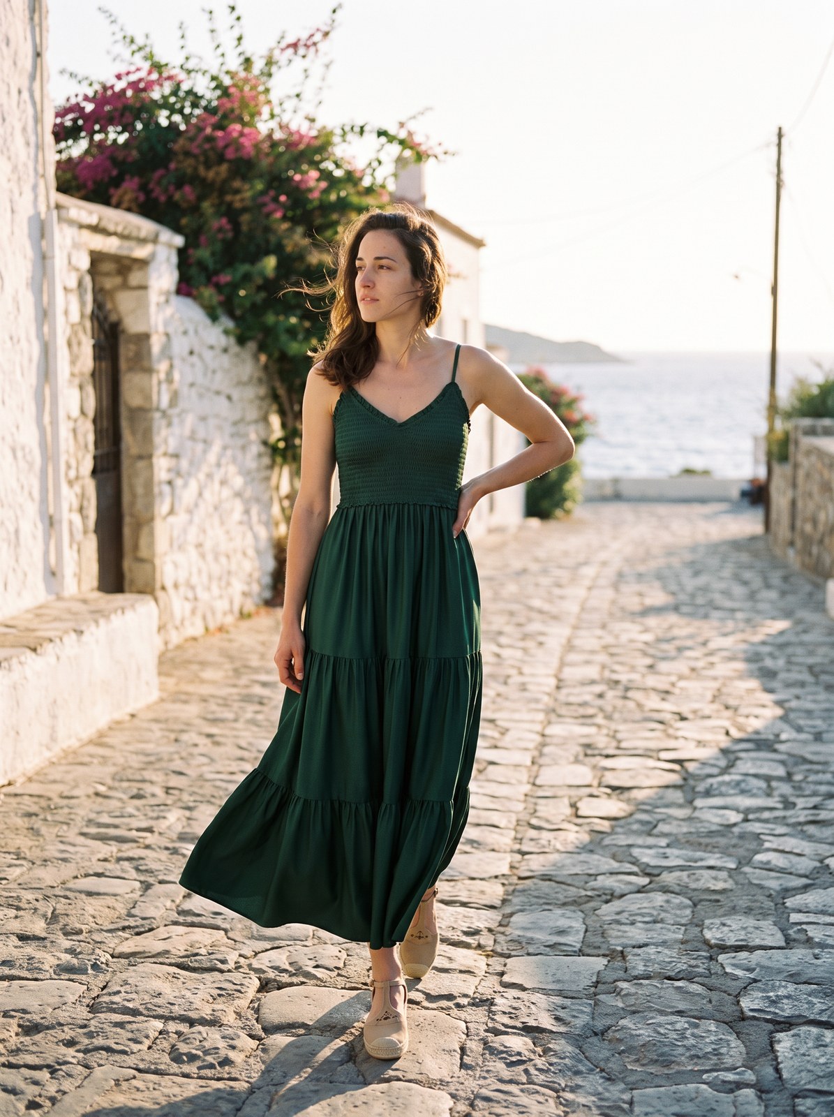 Golden hour campaign editorial of the same AI fashion model in the green maxi dress on a Mediterranean street