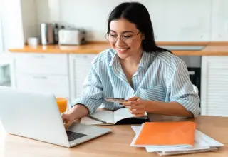 Woman with glasses sitting in the front of the laptop