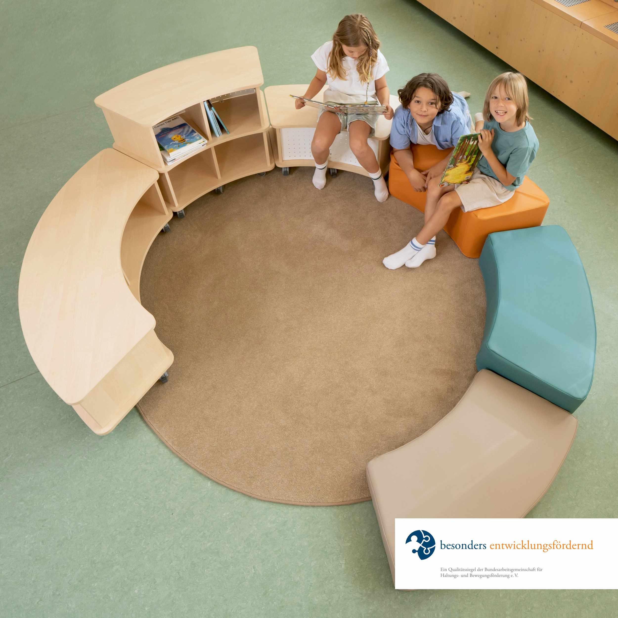 Foto eines Sitzkreises in der Kita aus runden Holzsitzbänken und runden Sitzpolstern in unterschiedlichen Höhen mit Spielzeug darauf