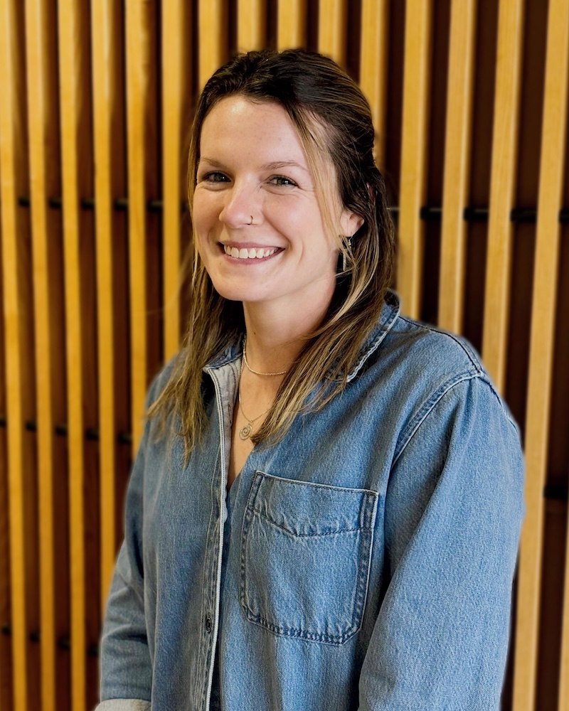 Smiling woman in denim shirt against gold striped background