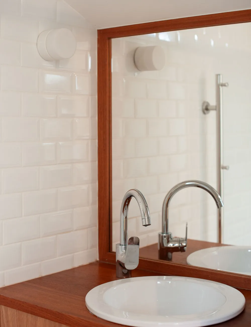 vasque et meuble en bois foncé dans salle de bain