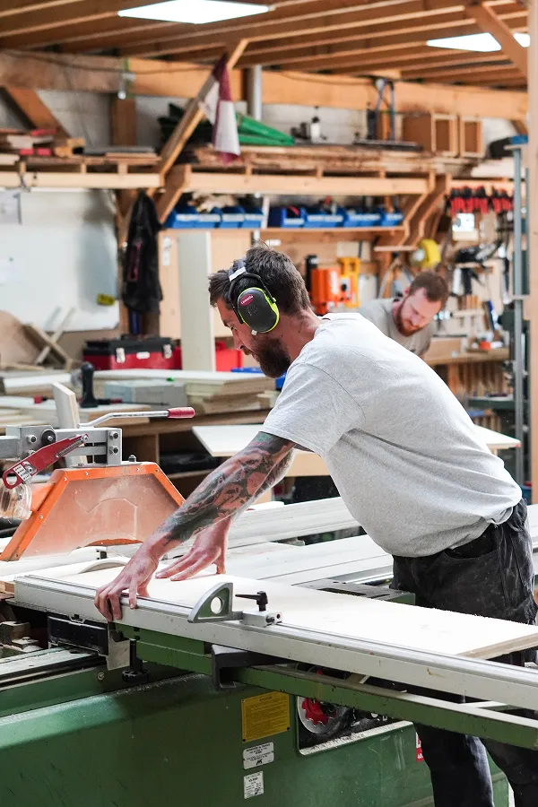 menuisier sur machine découpe dans atelier de menuiserie à Bordeaux