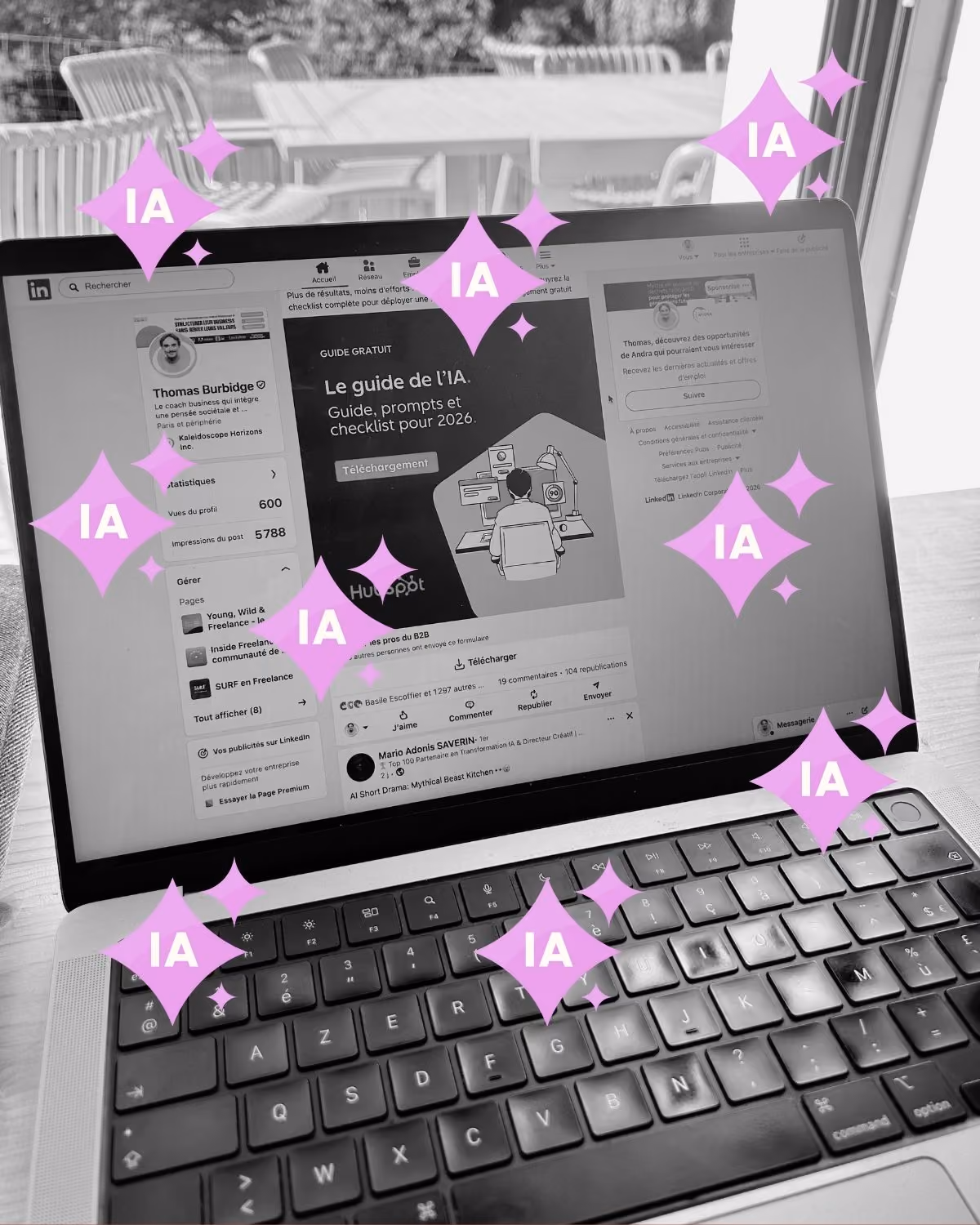 Ordinateur portable ouvert affichant une page LinkedIn avec un guide gratuit sur l'intelligence artificielle, entouré d'illustrations roses en forme d'étoiles portant les lettres IA, sur une table en bois près d'une fenêtre.