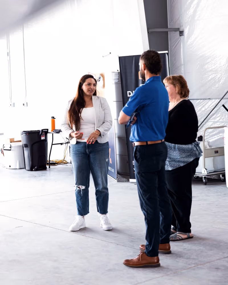 Group of people standing and talking in a modern indoor space.