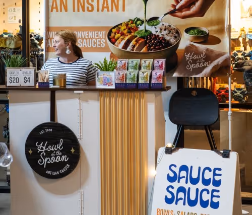 A woman standing behind a counter in a store.