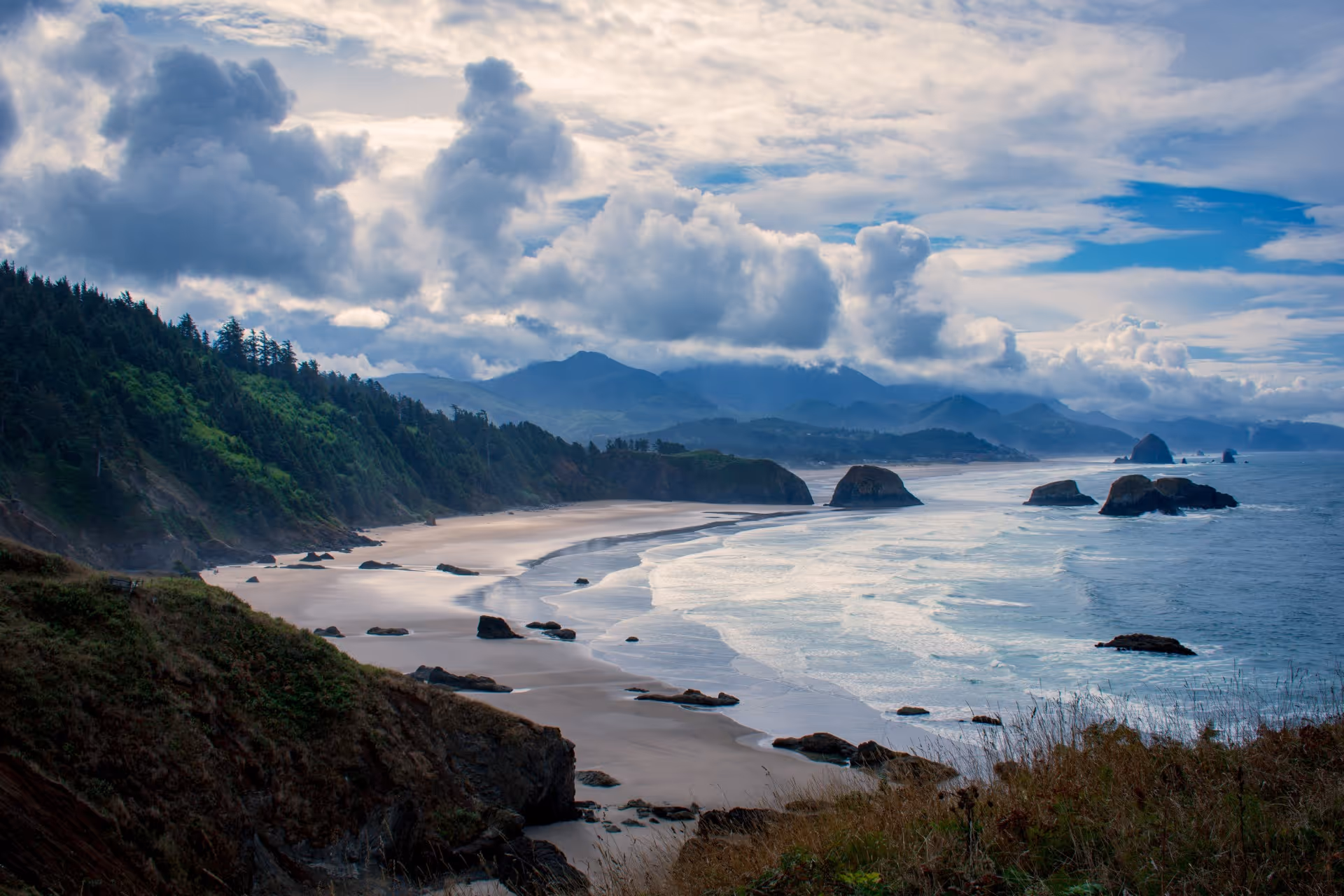A view of a beach with mountains in the background.