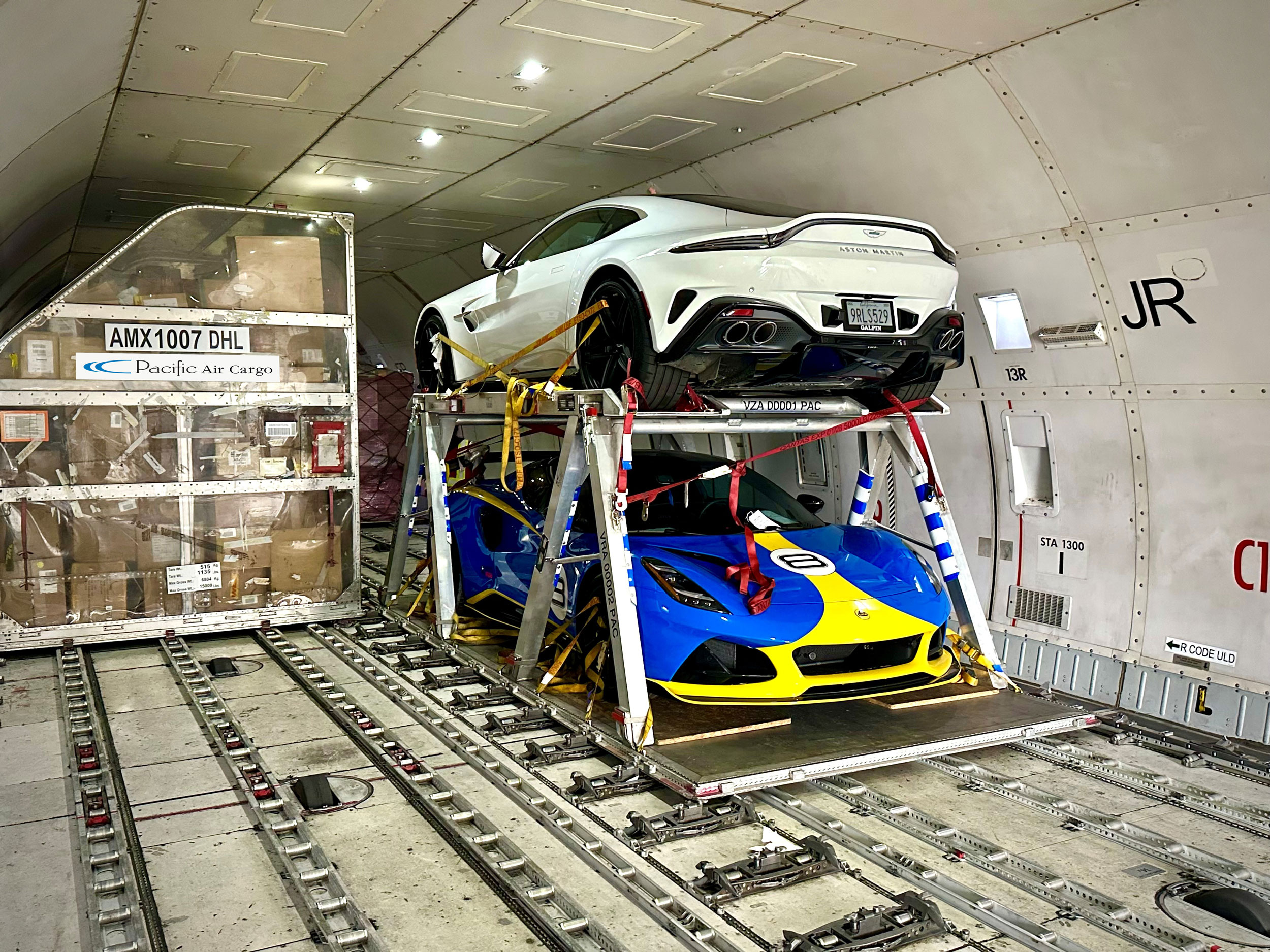 Luxury sports cars secured inside Pacific Air Cargo aircraft for transport