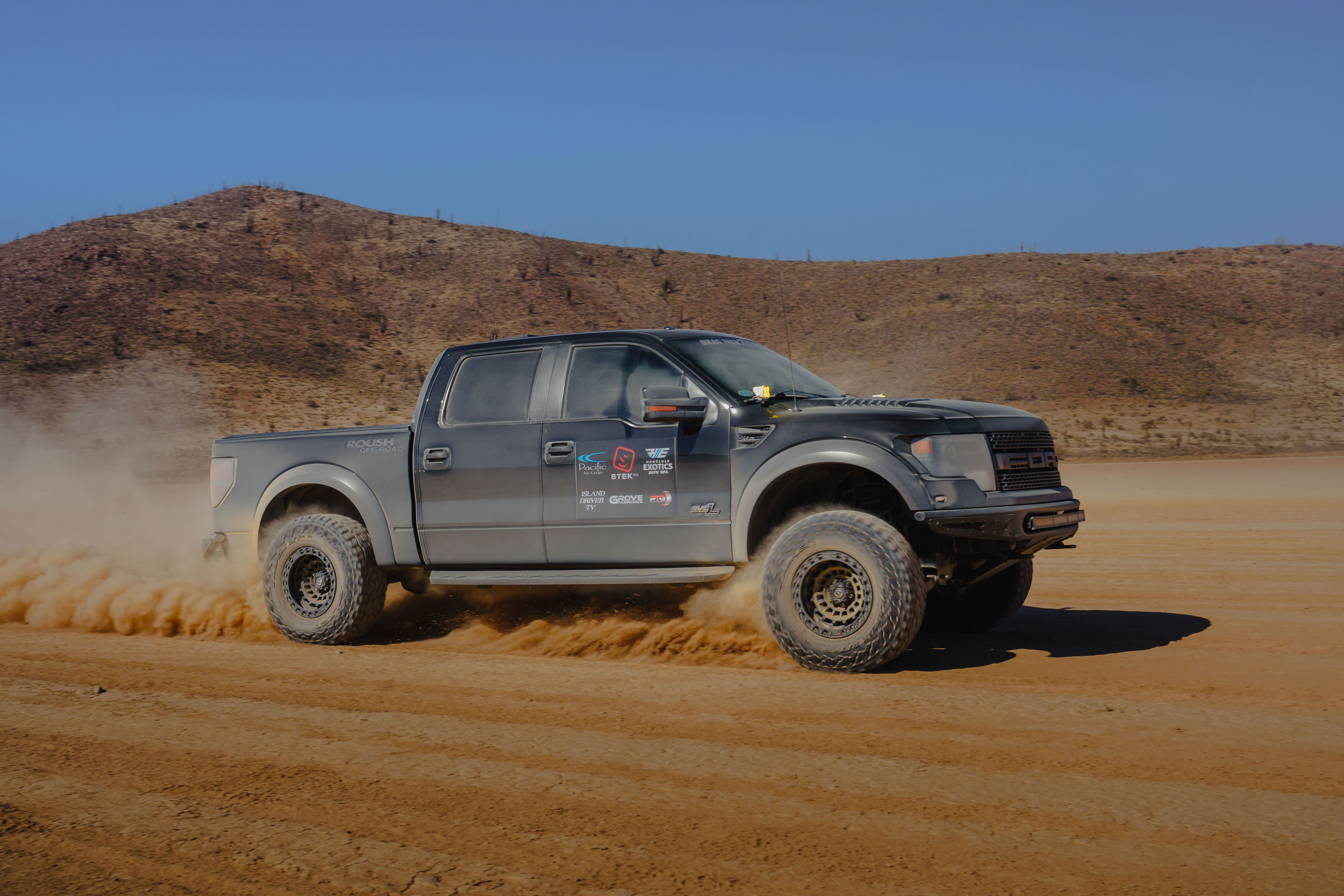 Black Ford Raptor off-road truck with Pacific Air Cargo sponsorship in desert