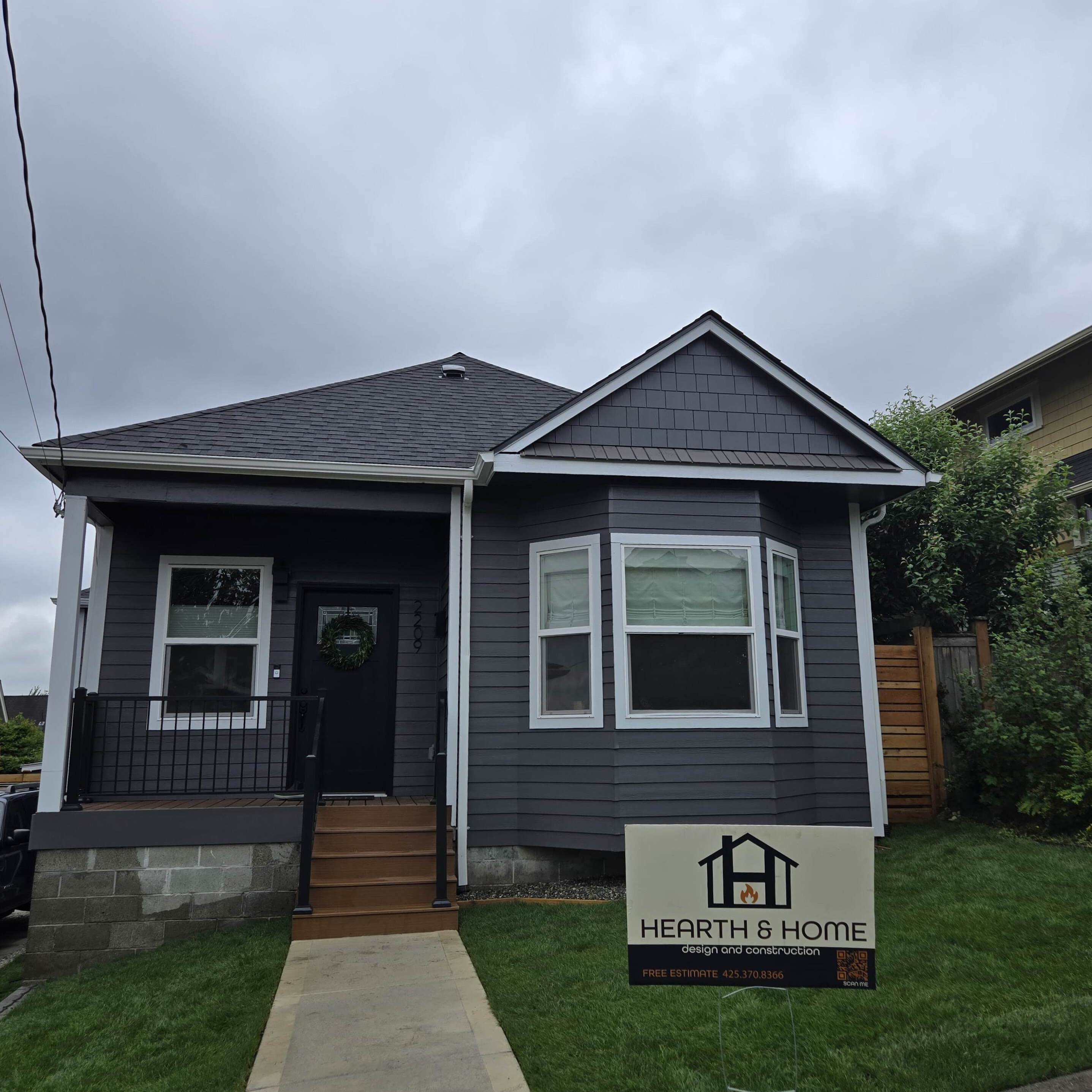 Renovated home exterior with new siding and freshly planted green lawn