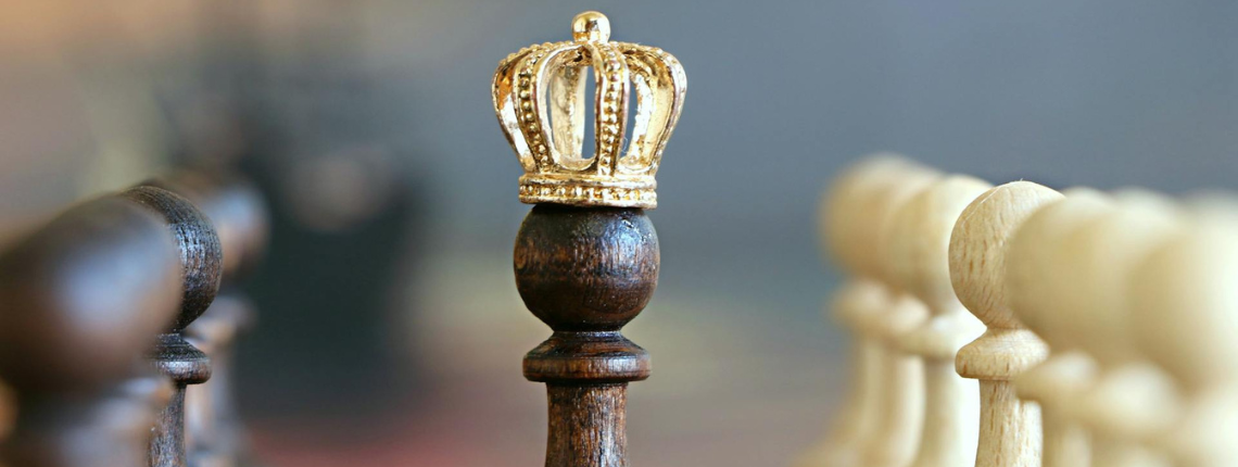 Chess pieces with a crown placed on a pawn — symbolising the power of strategic leverage turning small actions into big outcomes.