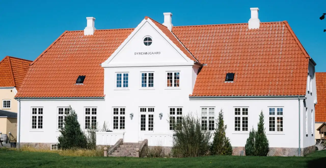 A white house with a red tiled roof.