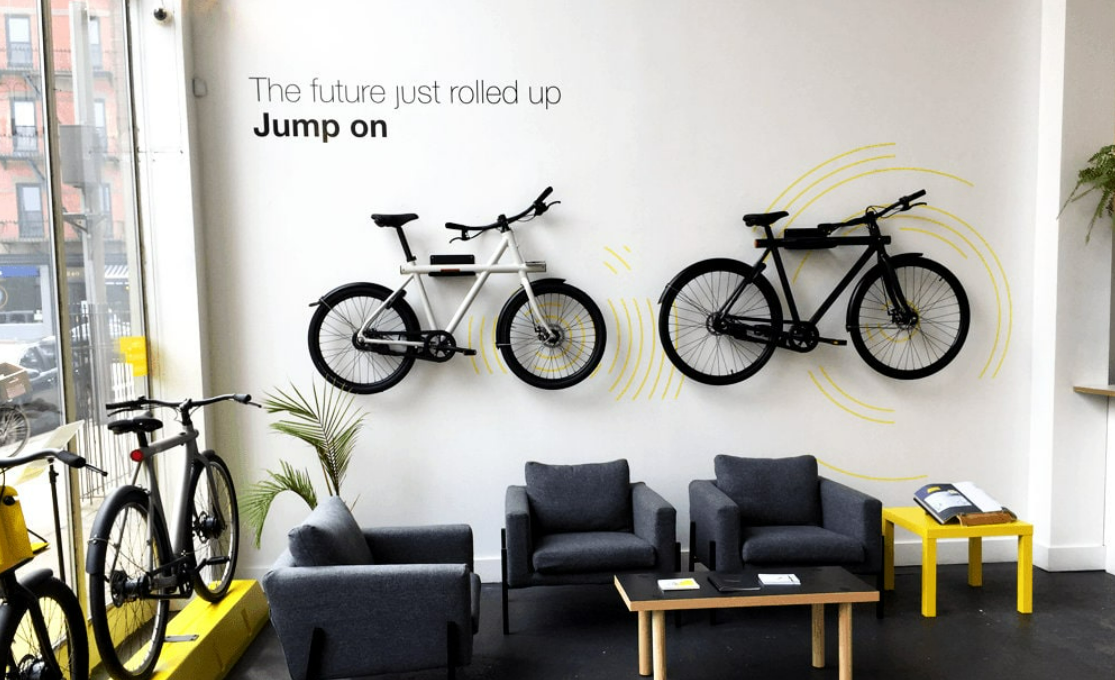 Wall art with bikes mounted on the wall and a sign that reads "The future just rolled up. Jump on"