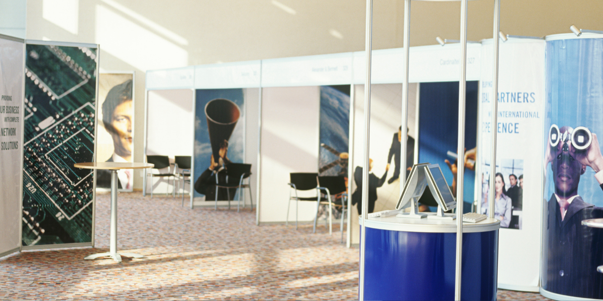 Stands at a trade show with large format prints in the background