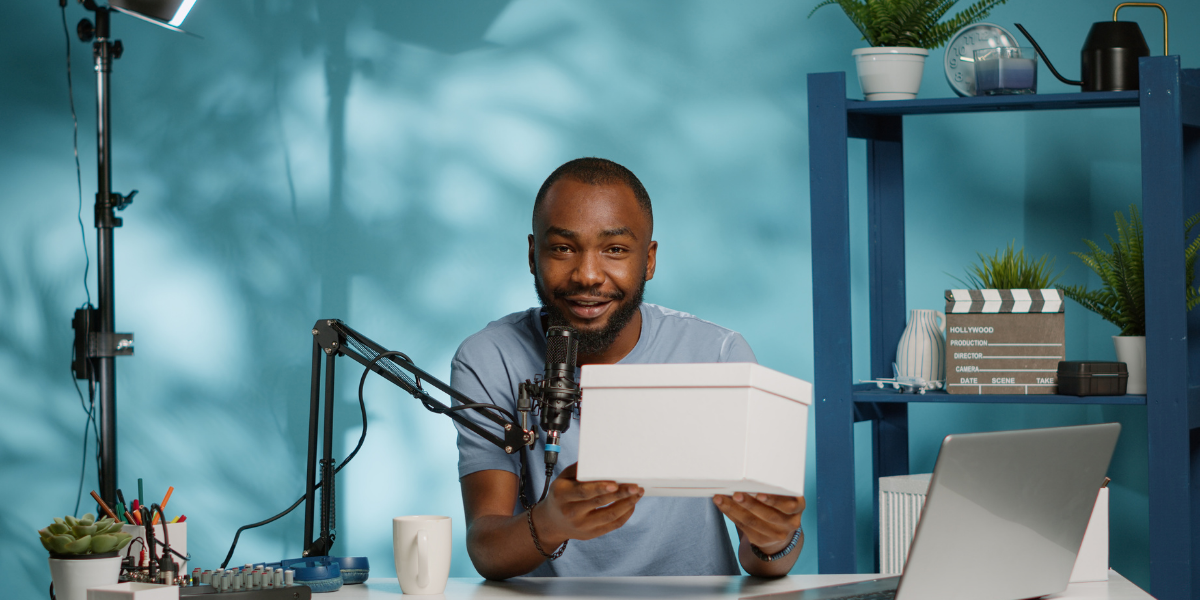 Male influencer holding a box and speaking on a mic