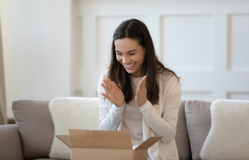 Customer smiling while opening a custom shipping box at home