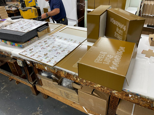 Custom printed luxury packaging boxes on a production worktable