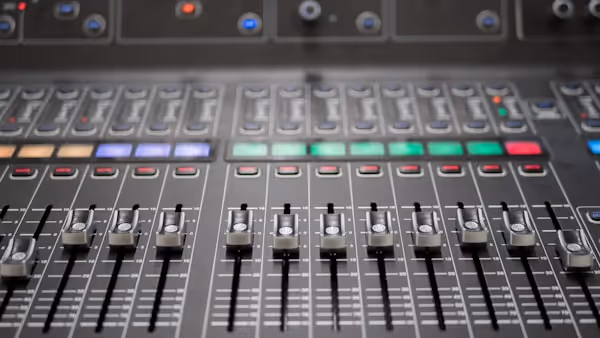 A closeup of an audio mixing console.