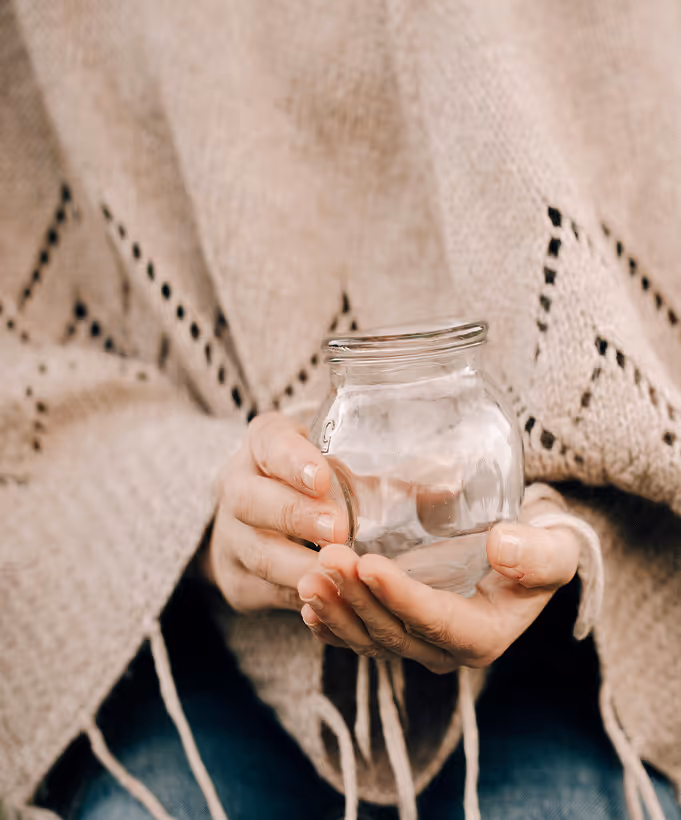 Una mujer sosteniendo un cristal para Cupping.