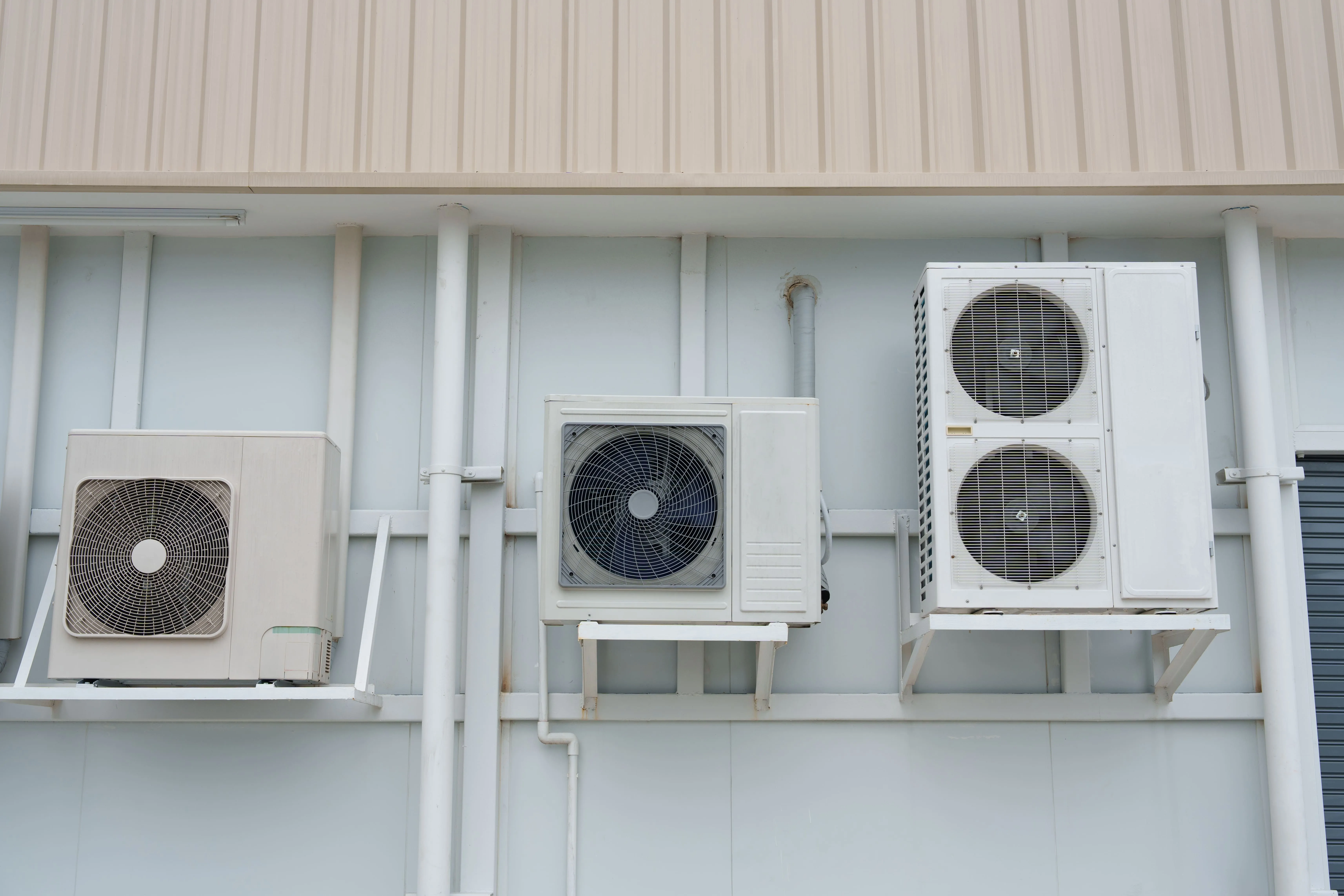 Wall-mounted air conditioning units installed on a commercial building exterior.
