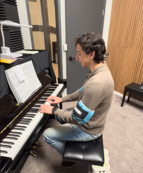 Beginner adult playing the piano with arm weights at Pianoramic Studios