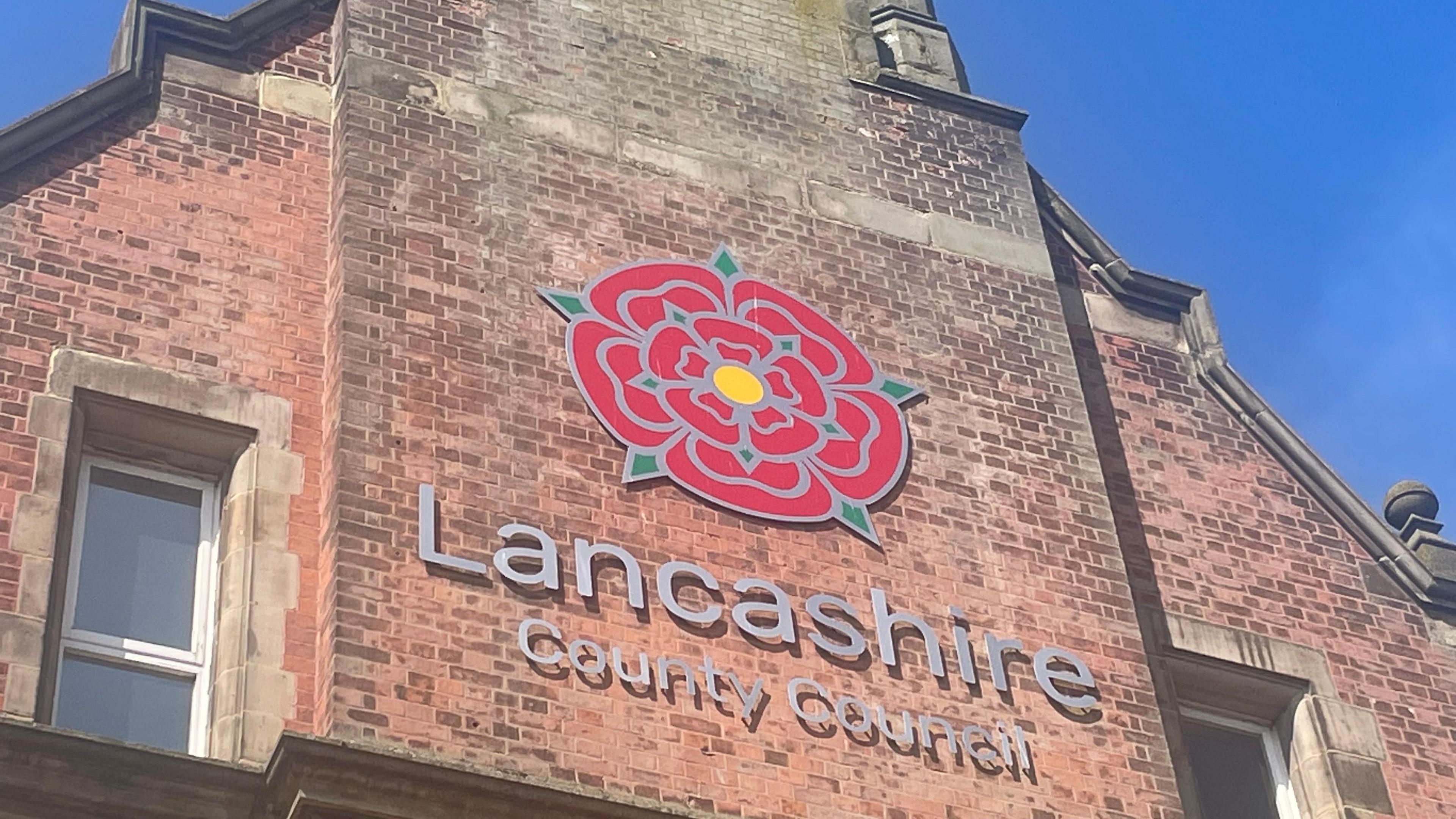 Lancashire County Council building with red rose logo on brick facade