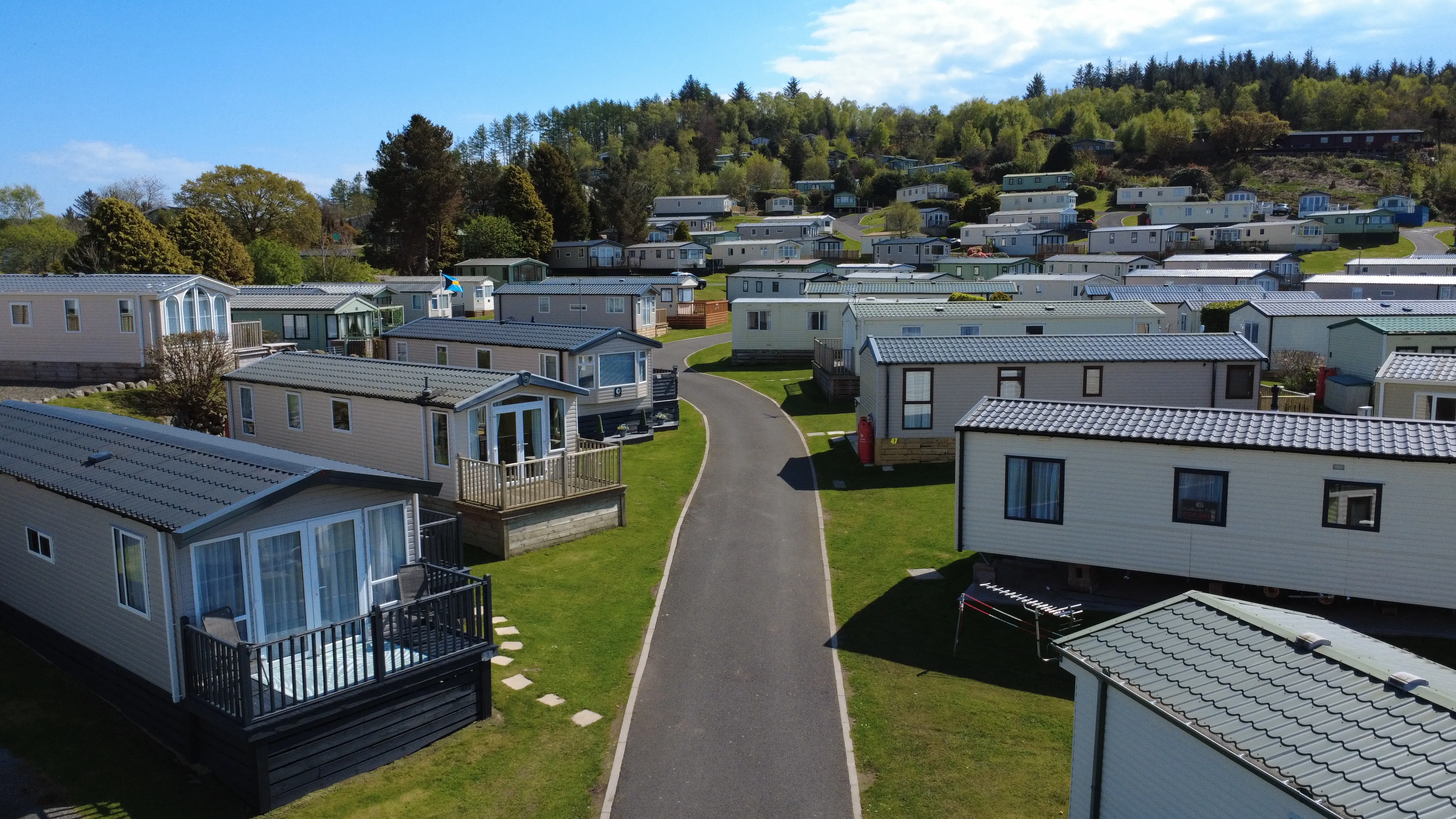 Aerial view of mobile home park with white trailers and green landscape