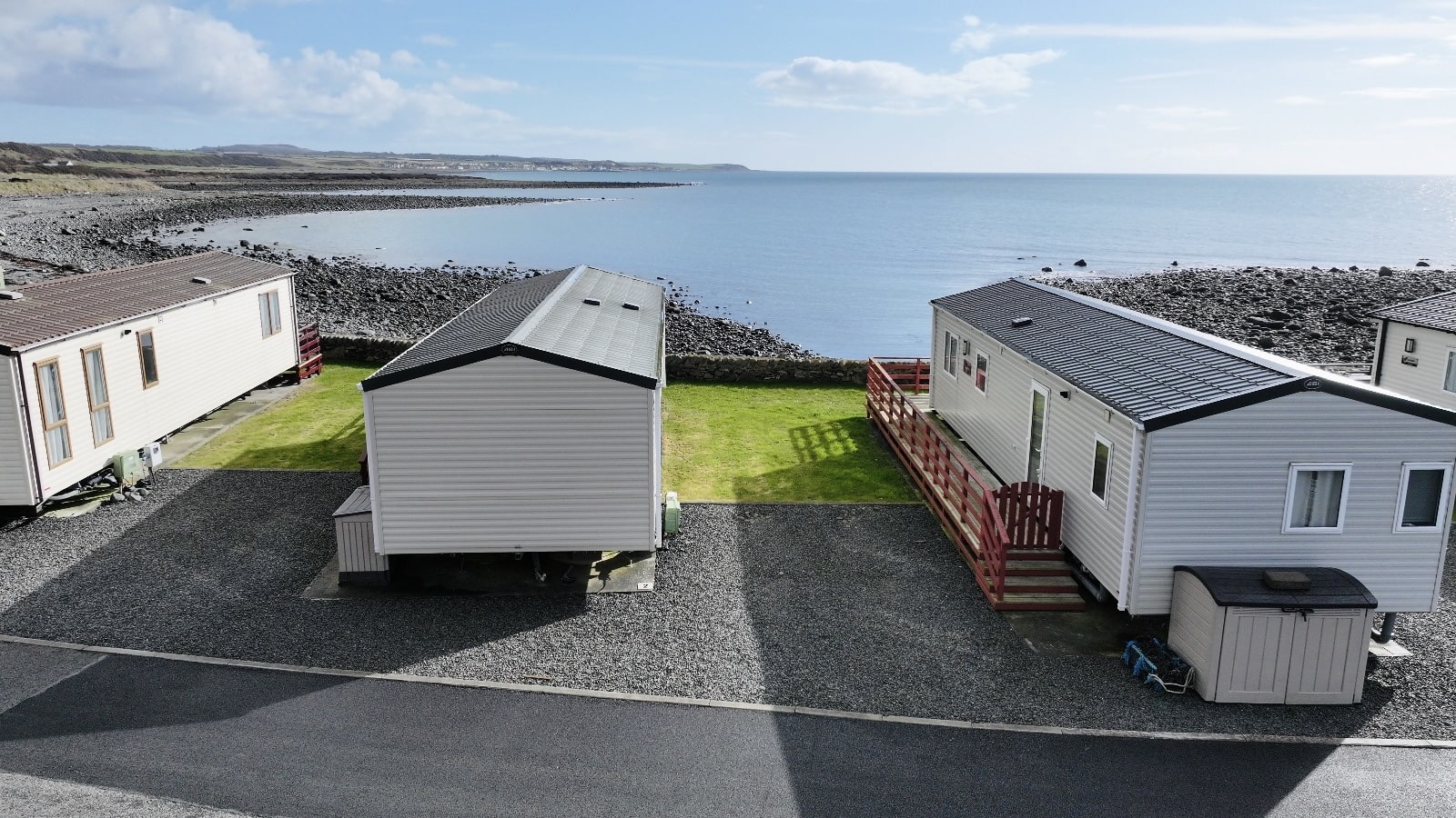 Mobile homes on rocky coastal site with expansive ocean and sky view