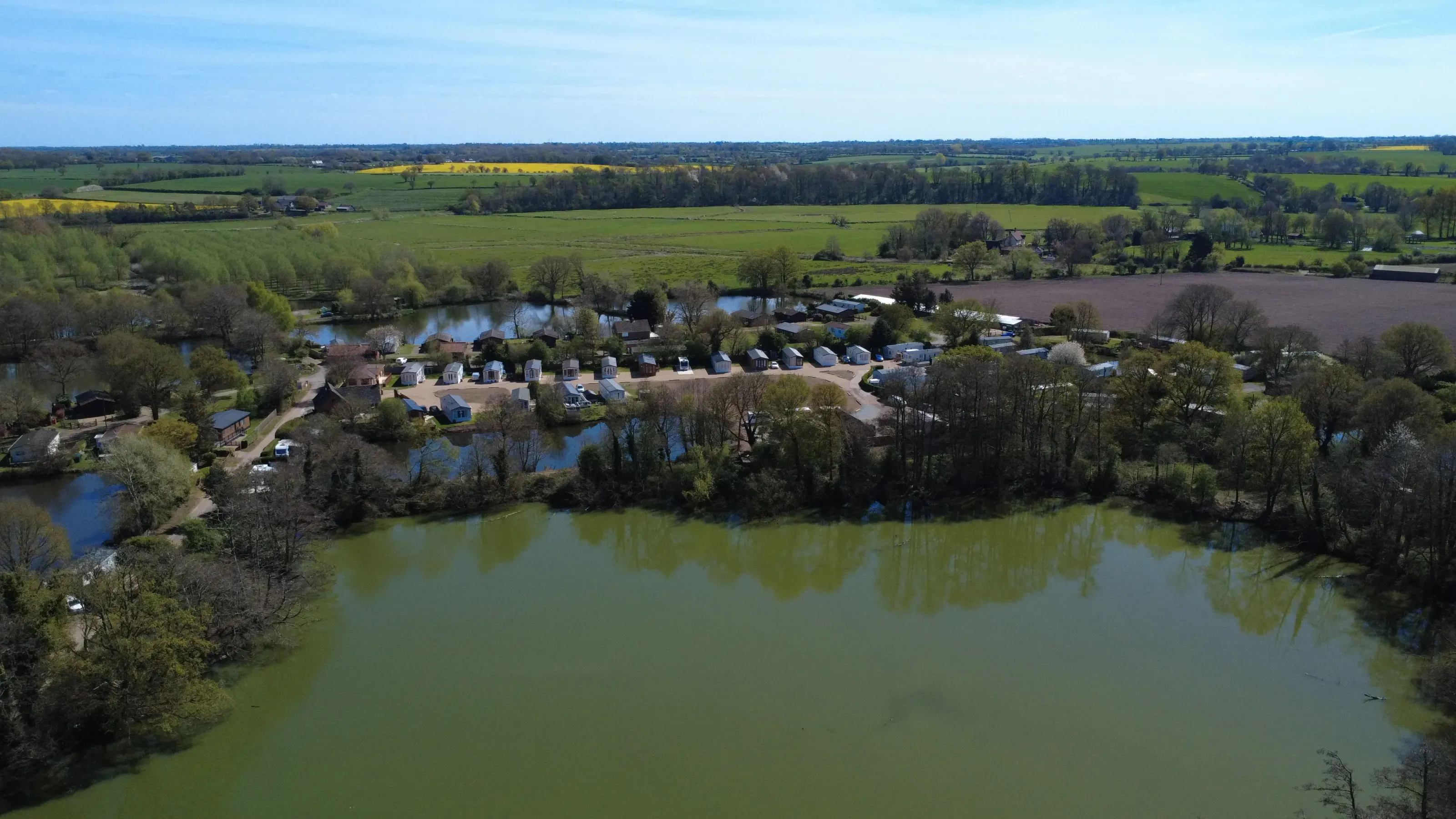 Aerial view of lakeside mobile home park surrounded by green fields