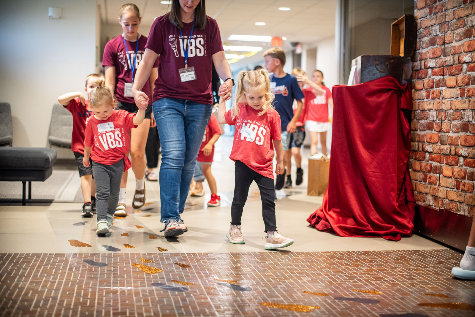 children walking with adult holding hands