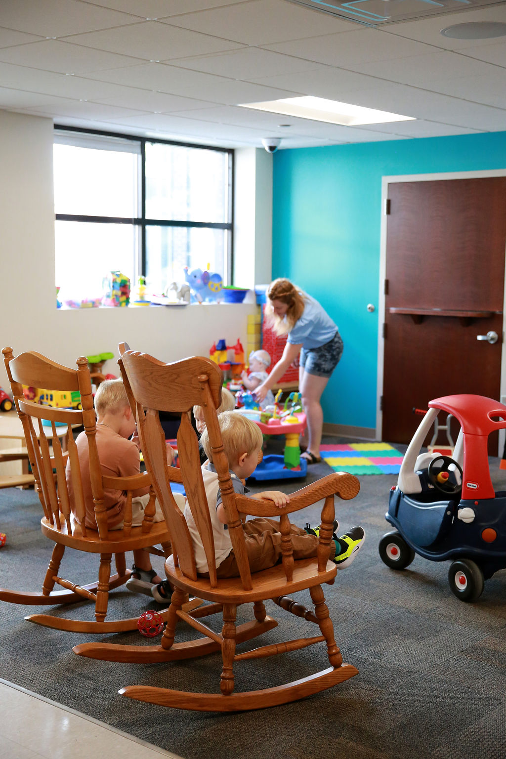children and woman in nursery
