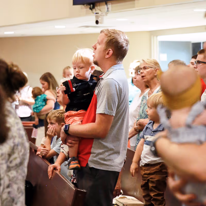 Father holding son while singing