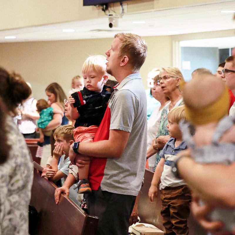 Father holding son while singing
