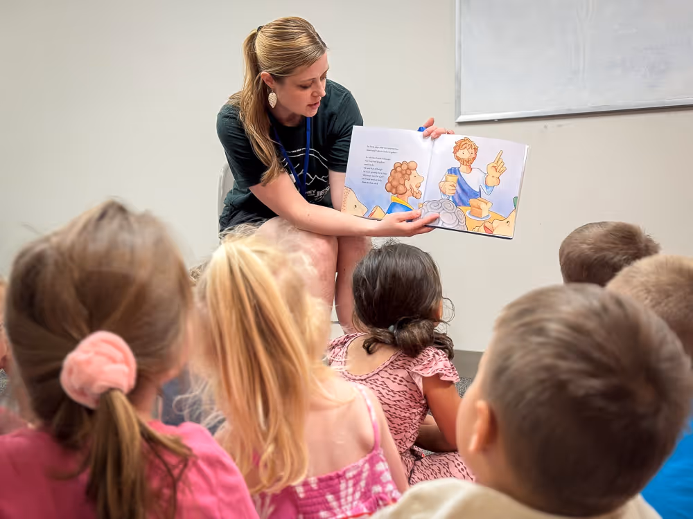 woman reading a book to children