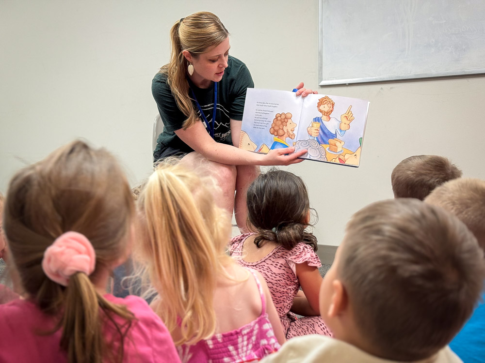 woman reading a book to children