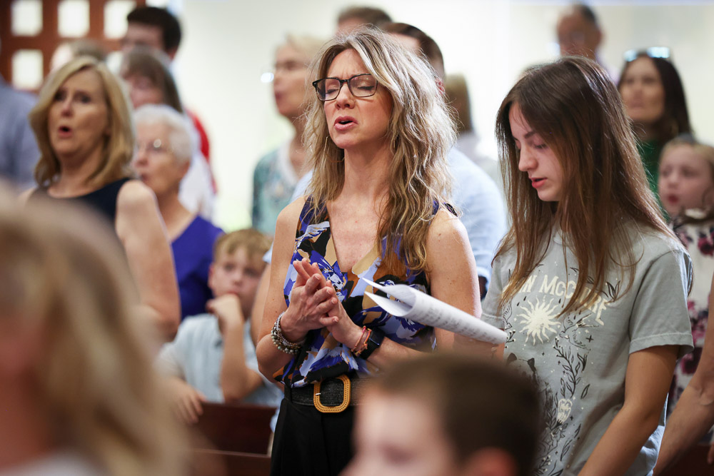woman singing with others in a church