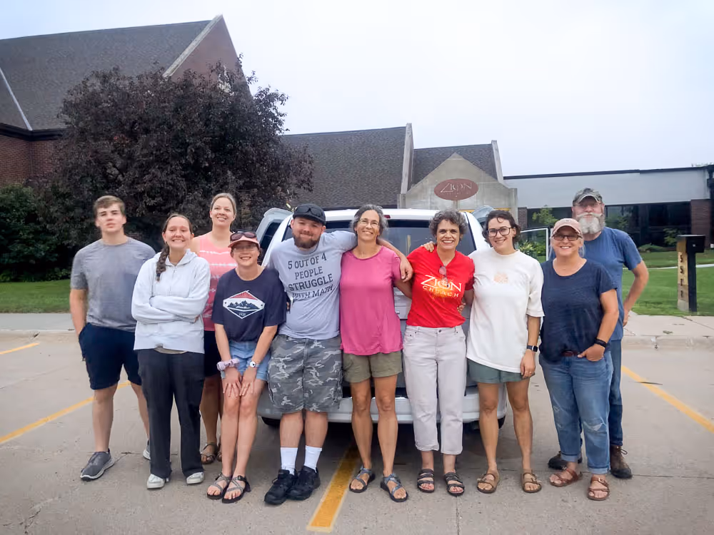 men and women standing in front of a church
