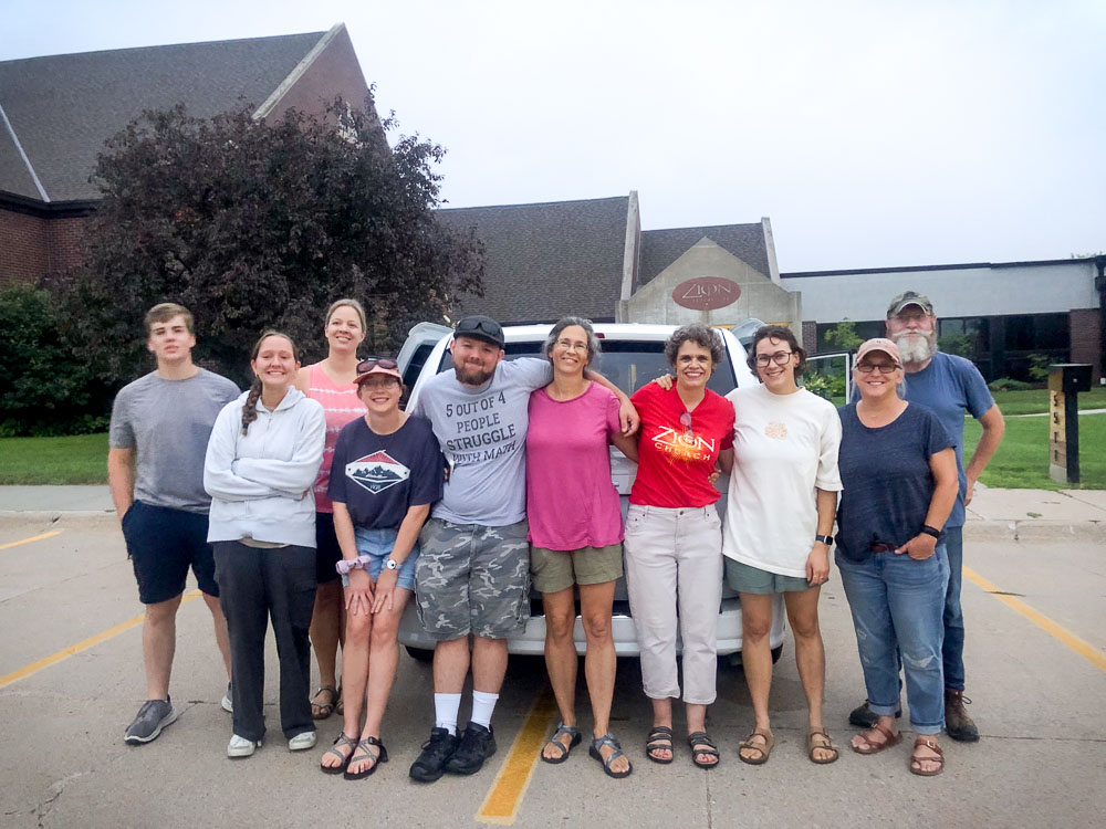 men and women standing in front of a church