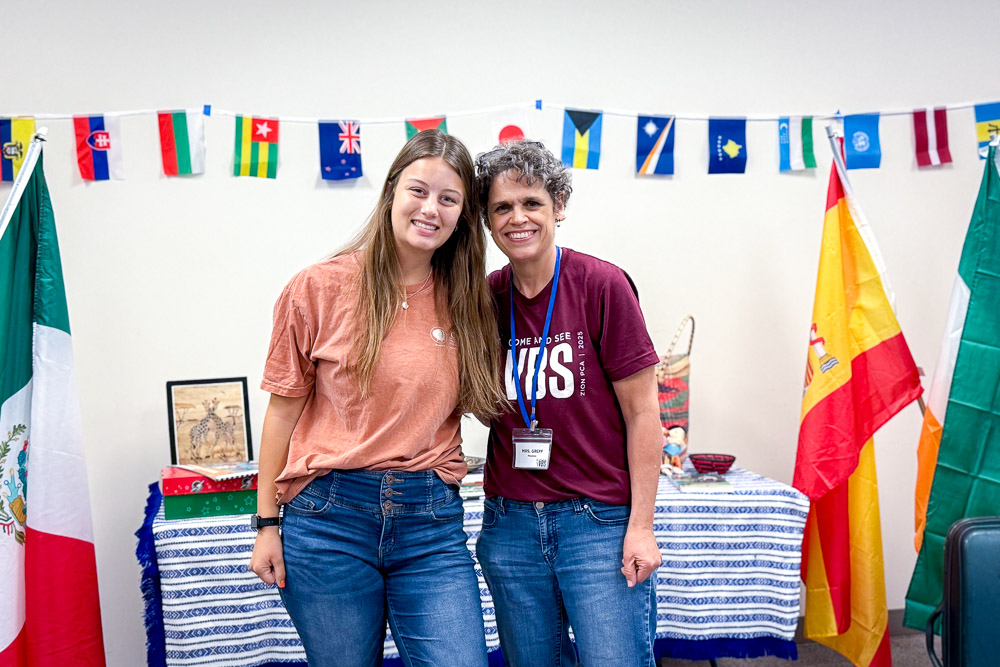 two women standing in front of flags