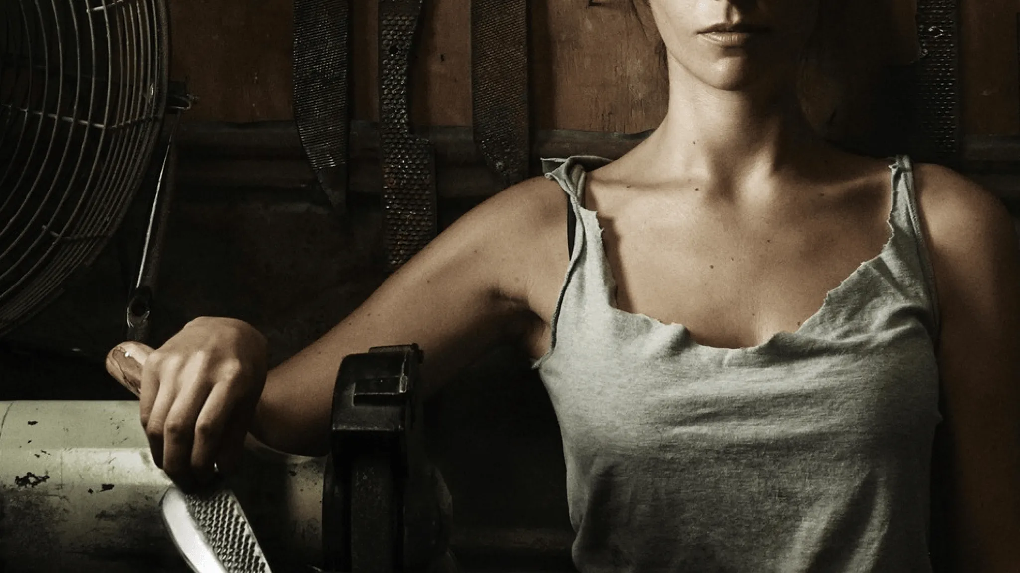 Close-up of a woman in a workshop setting holding a tool
