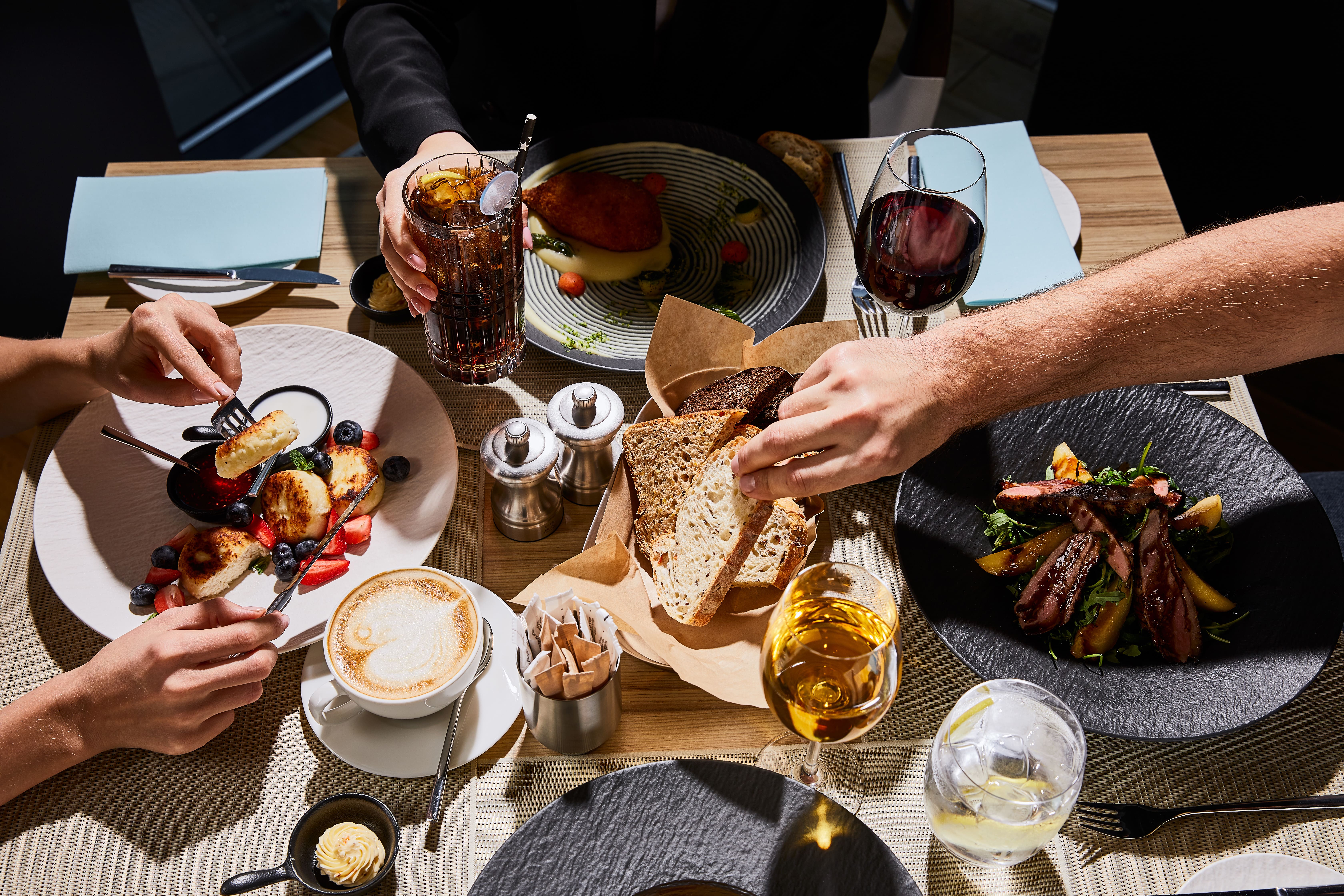 Close-up view of a group of people eating delicious brunch.