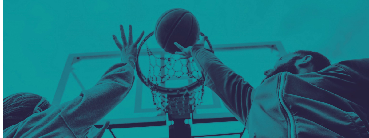 Deux joueurs de basketball disputent le ballon sous le panier lors d’un entraînement