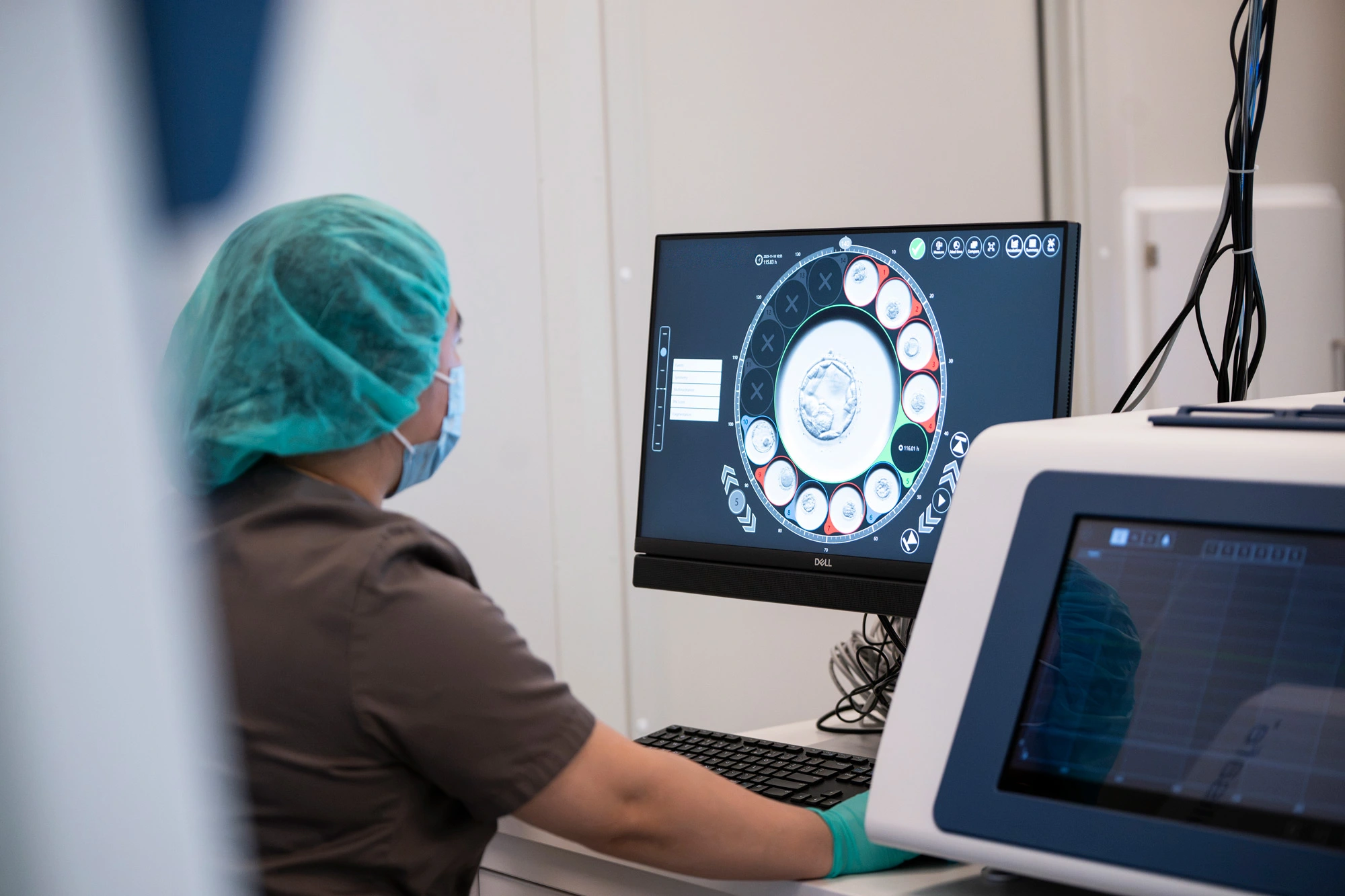 Embryolog følger embryoutvikling på skjerm fra inkubator