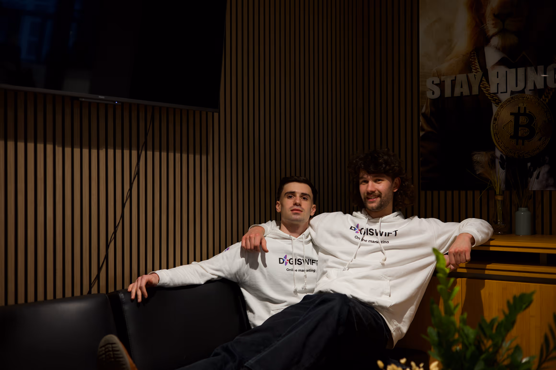 Daniel en Jon van DigiSwift ontspannen samen op de bank in kantooromgeving tijdens informele teammomenten