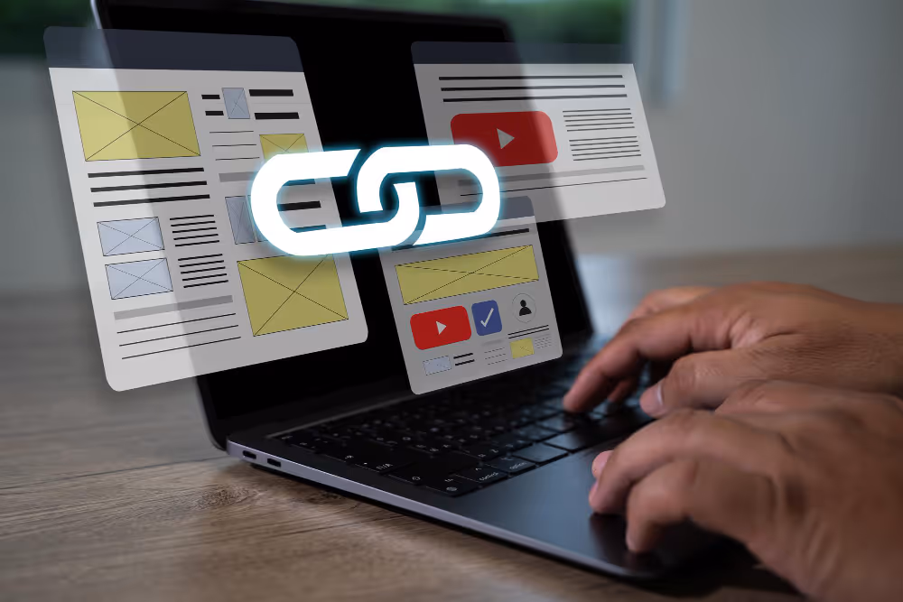 Close-up van handen die typen op een laptop met digitale link-icoon en websitedesigns, symbool voor backlinkstrategie in SEO.