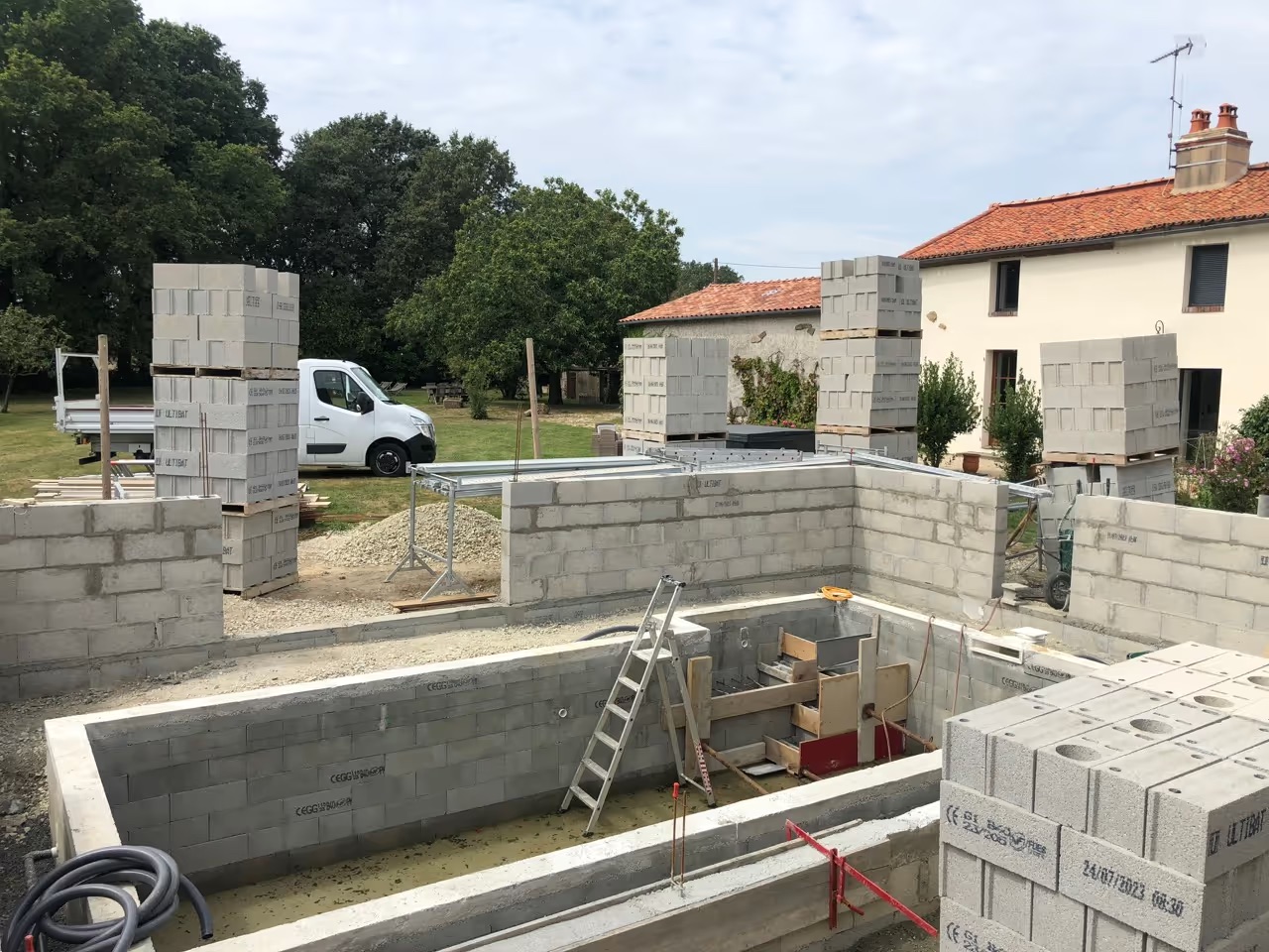 Un homme portant un bloc de béton à côté d'une brouette